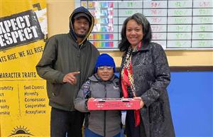 Parent with his student who won the pizza raffle along with Attedance Agent posing for the camera