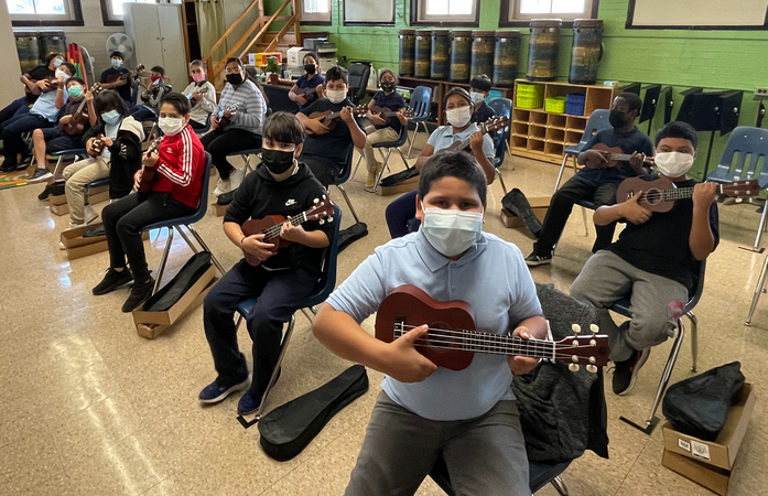 5th grade students wearing masks and playing ukuleles