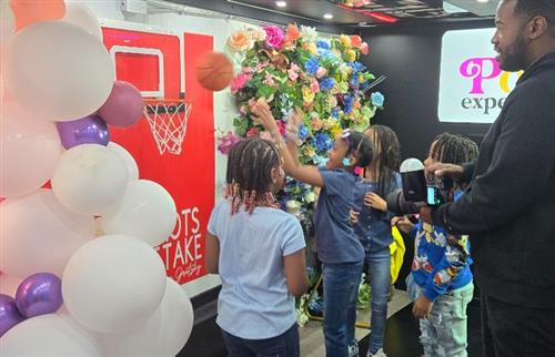 students in selfie boutique throwing a basketball into a hoop