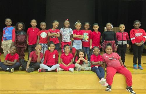 first graders on stage wearing red