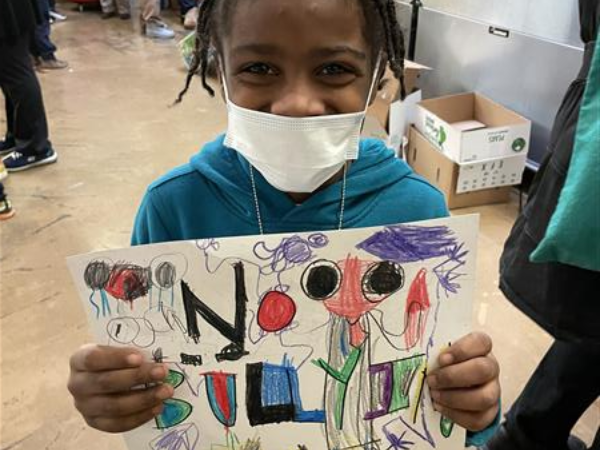 little girl holds an anti-bullying poster